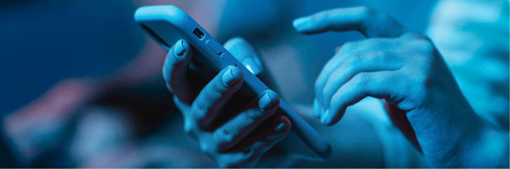 Imagem de uma mão segurando um celular